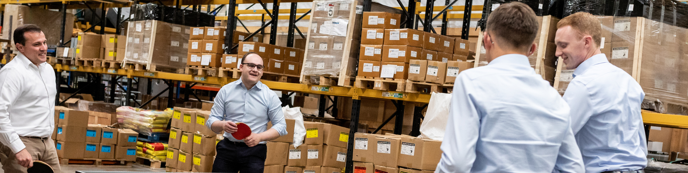 Ezi Klamp team playing table tennis in warehouse